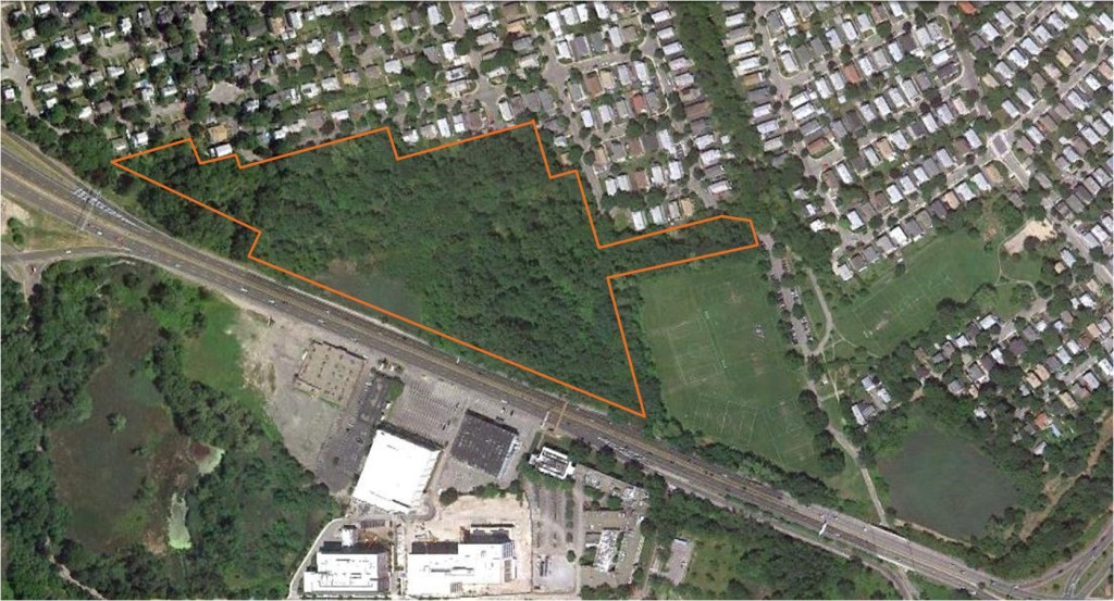 The Mugar parcel, outlined in white, abuts Route 2 (center). This 2011 aerial photo also depicts the former Faces site and parking lot (bottom), now the location of the Vox on 2 apartments. / Arlington Land Trust