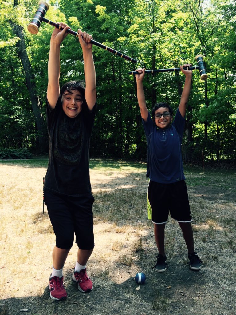 Croquet enthusiasts Jack Corrigan (left) and Ibrahim Halsobhi celebrate a winning run through the wickets.