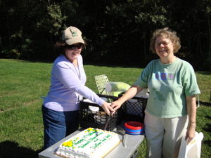 Waltham Land Trust vice president Diana Young (left) and Belmont Citizens Forum board member Sue Bass cut a joint 10th anniversary cake, September 2009.