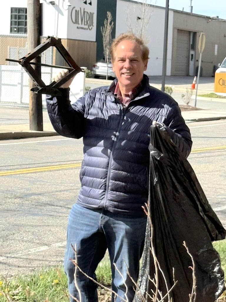 Dave Rogers finds a tire jack while cleaning up trash along Pleasant St