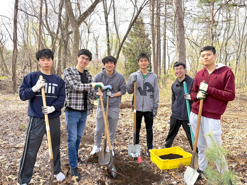 A group of high school students poses with tools at Lone Tree Hill